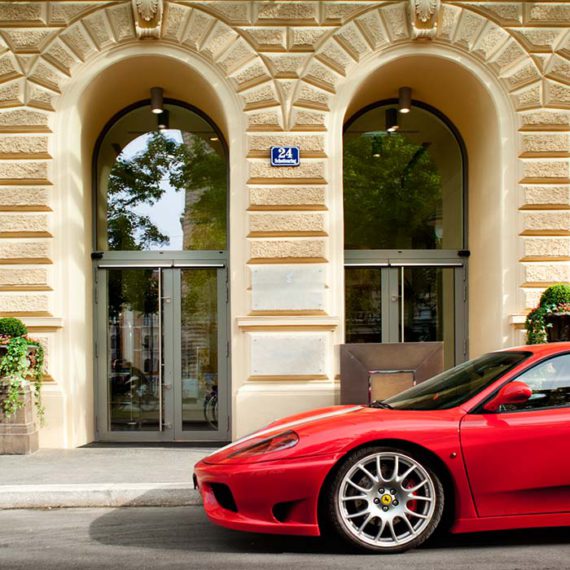 Eingang des Palais Hansen Kempinski mit davor geparktem Ferrari © Robert Tober